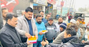 लड्डू बांटते हुए डिंपल राणा व अन्य